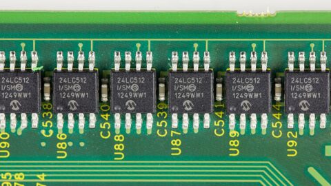 Close-up of black microchips mounted in a row on a green circuit board