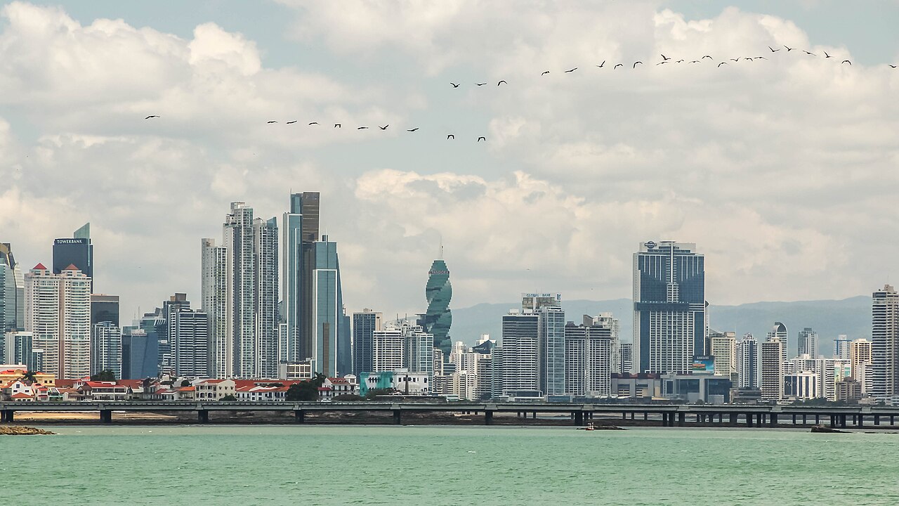 Panama City skyline of towers across the water under cloudy skies